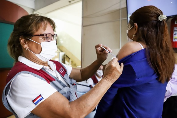 epa09870566 People receive a dose of a vaccine against COVID-19, influenza or Pneumo 23, at a vaccination center of the XVIII Sanitary Region in Asuncion, Paraguay, 04 April 2022. Within the framework ...