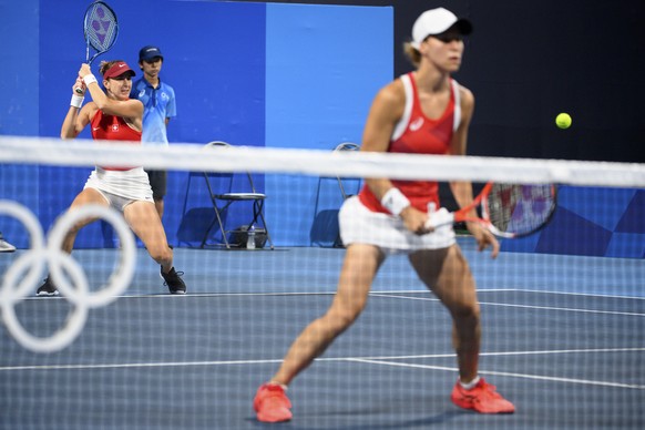 Belinda Bencic, left, and Viktorija Golubic, right, of Switzerland return a ball to Laura Pigossi and Luisa Stefani of Brazil during the women&#039;s doubles tennis semifinal at the 2020 Tokyo Summer  ...