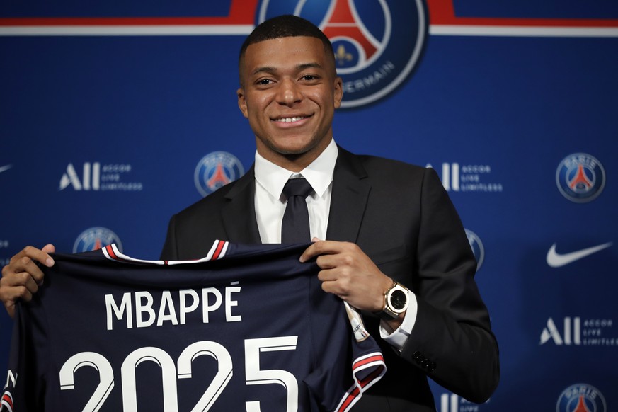 epa09969499 Paris Saint Germain&#039;s Kylian Mbappe poses with a PSG jersey after his press conference at the Parc des Princes stadium in Paris, France, 23 May 2022. Kylian Mbappe renewed his contrac ...