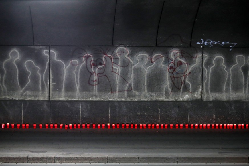epaselect epa08562929 Candles are prepared in front of outlines of visitors to the Love Parade 2010 in a tunnel near the disaster memorial in Duisburg, Germany, 23 July 2020. The commemoration of the  ...