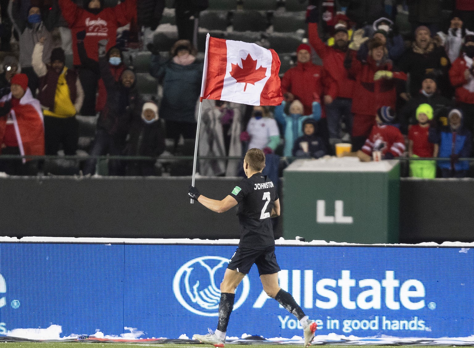 Canada&#039;s Alistair Johnston (2) parades the flag to celebrate the team&#039;s win over Mexico during a World Cup soccer qualifying match in Edmonton, Alberta, Tuesday, Nov. 16, 2021. (Jason Franso ...