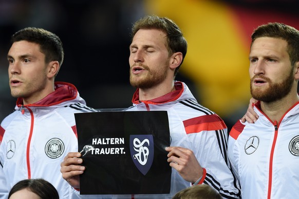 KAISERSLAUTERN, GERMANY - MARCH 25: Benedikt Hoewedes of Germany holds up a banner in remembrance of the victims of Germanwings flight 4U9525 prior to kickoff during the International Friendly match b ...