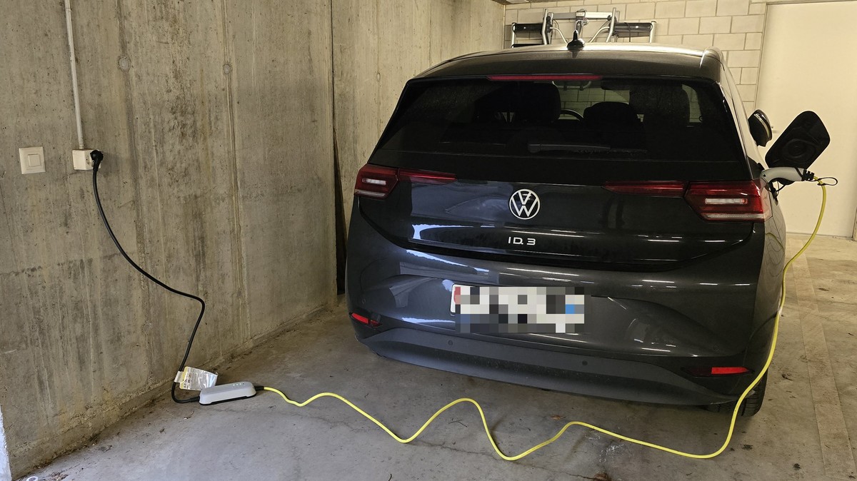 Ein E-Auto lädt per Notladekabel an der Steckdose.