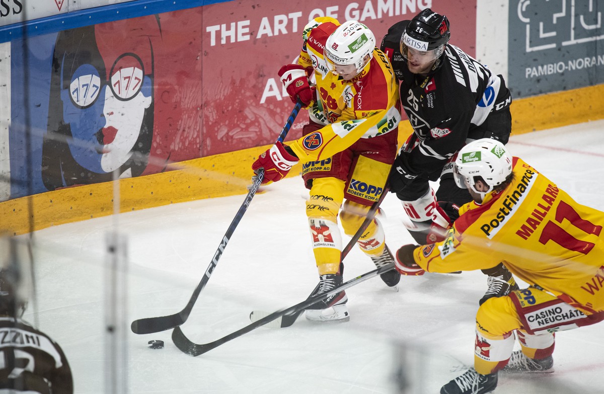 From left, Bienne's player Beat Forster and Lugano's player Mirco Mueller, during the preliminary round game of the National League 2022/23 between HC Lugano against EHC Bienne at the ice st ...
