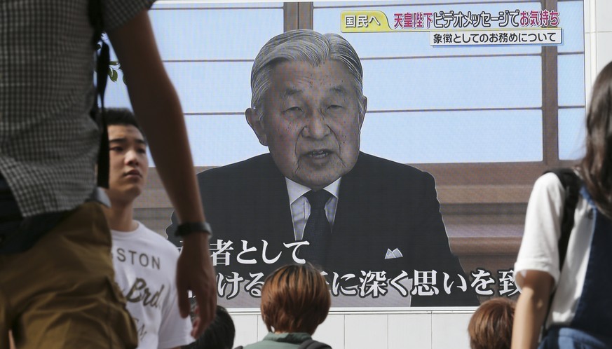 A screen displays Japanese Emperor Akihito delivering a speech in Tokyo, Monday, Aug. 8, 2016. The Japanese emperor, in a rare address to the public, signaled Monday his apparent wish to abdicate by e ...