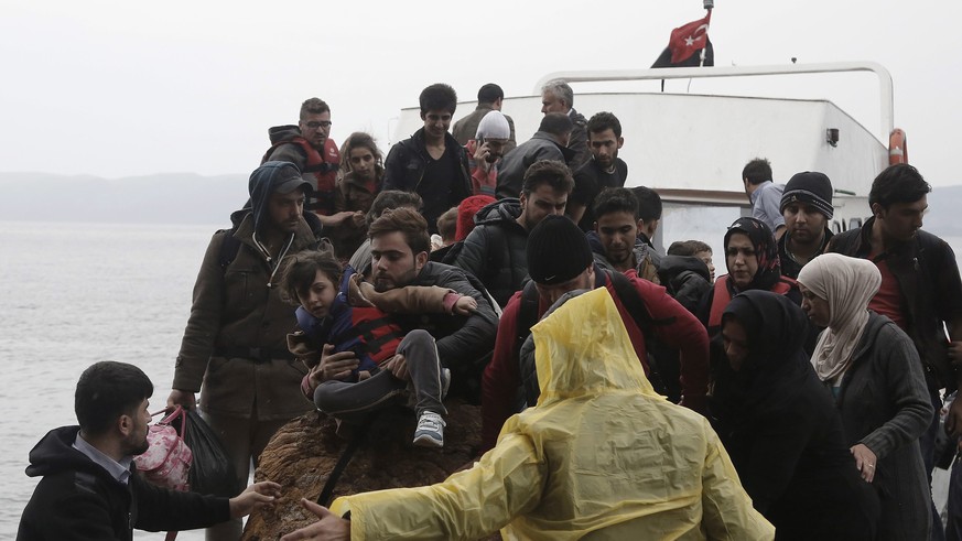 epa04973090 Refugees and migrants arrive on the island of Lesbos on an overcrowded fishing boat after crossing the Aegean sea from Turkey, Greece, 11 October 2015. A recently agreed European Union pla ...