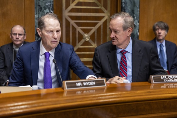 epa12352111 Ranking Member of the Senate Finance Committee Ron Wyden (L) talks with Senate Finance Committee Chairman Mike Crapo (R) during the Senate Finance Committee&#039;s hearing on The President ...