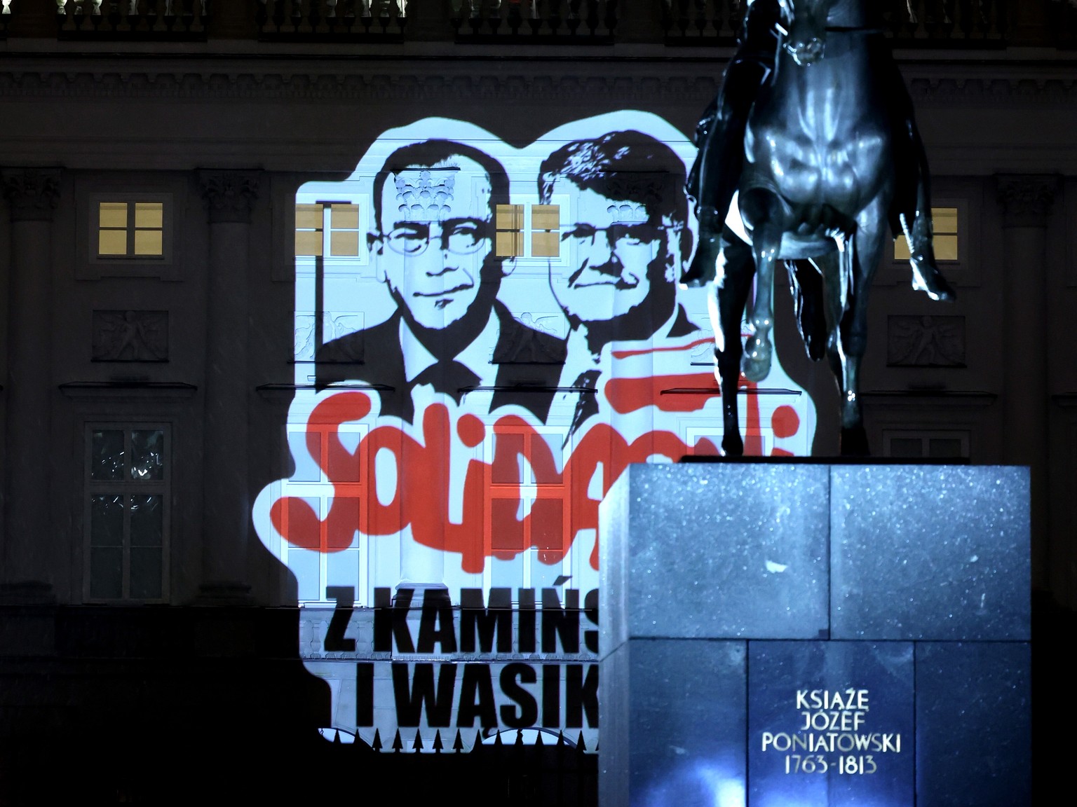 epa11069885 Graphics with the image of imprisoned Law and Justice party politicians, former Minister of Internal Affairs Mariusz Kaminski and his deputy Maciej Wasik, are displayed on the facade of th ...