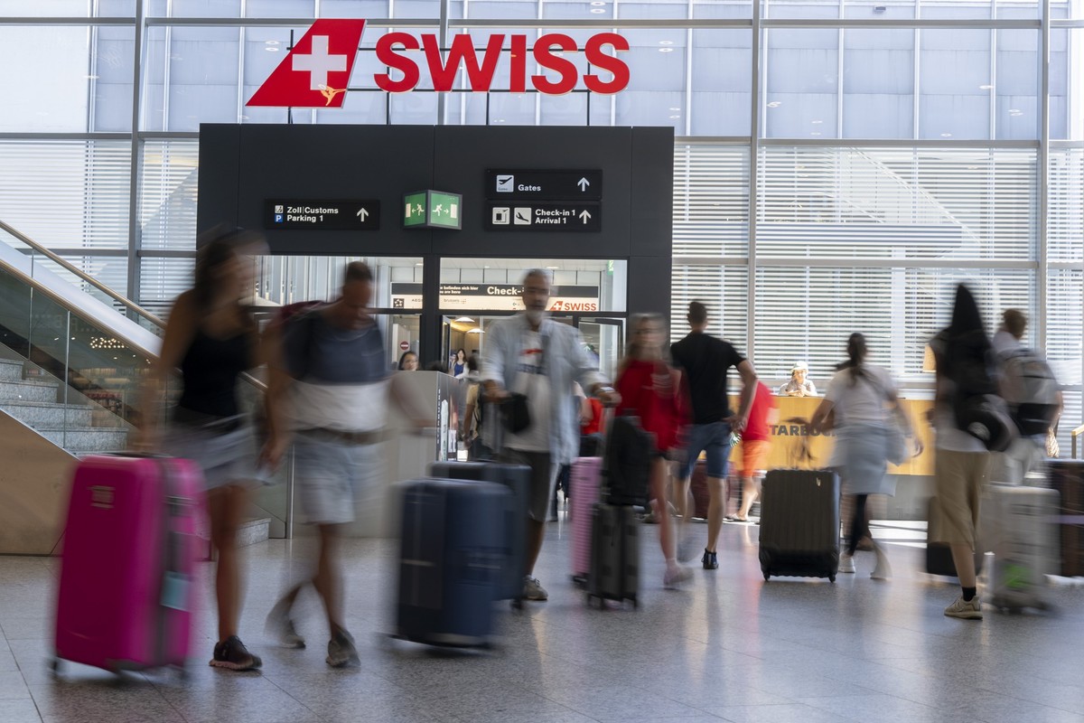 Passagiere gehen mit Koffer, Taschen oder Rucksaecken zum Ferienbeginn durch die Hallen zu den Check-In-Schaltern, am Samstag, 11. Juli 2026, am Flughafen Zuerich in Kloten. (KEYSTONE/Andreas Becker)