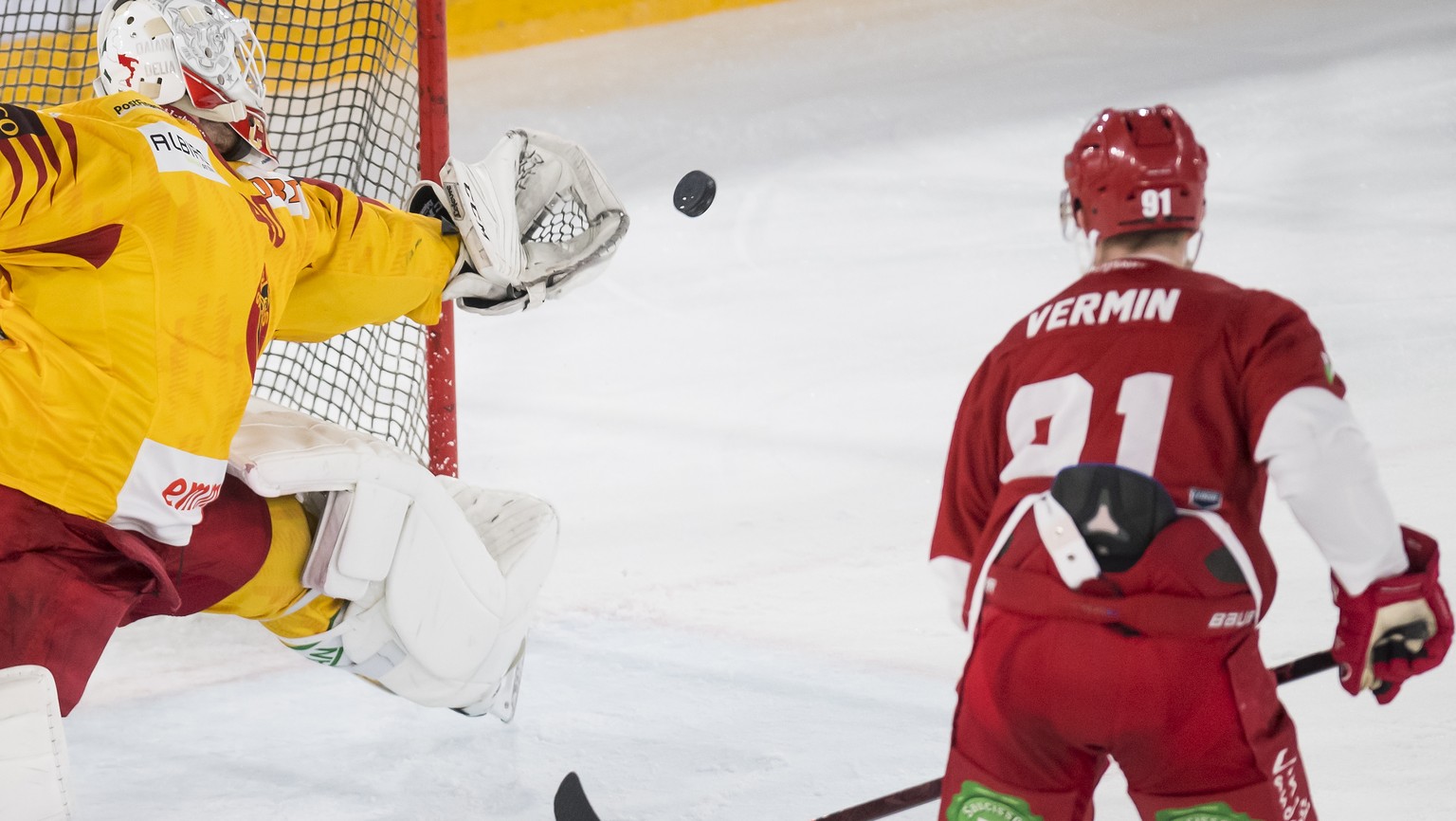 Le gardien de Langnau Damiano Ciaccio, gauche, lutte pour le puck avec l&#039;attaquant lausannois Joel Vermin, droite, lors de la rencontre du championnat suisse de hockey sur glace de National Leagu ...