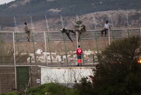 Flüchtlinge überklettern den Grenzzaun in Melilla.&nbsp;