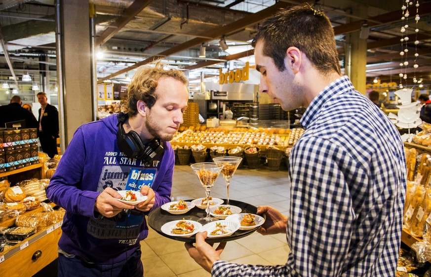 epaselect epa04471302 An employee offers snacks made of insects to a customer in a store of Dutch supermarket chain Jumbo in Groningen, The Netherlands, 31 October 2014. From January 2015 onwards, pro ...