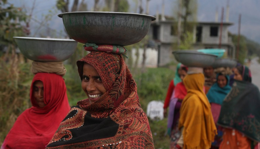 epa05834611 Indian women come back after working in a mustard field on the eve of International Women&#039;s Day at Baldhar village, some 15 km from Dharamsala, India, 07 March 2017. Mustard, formerly ...