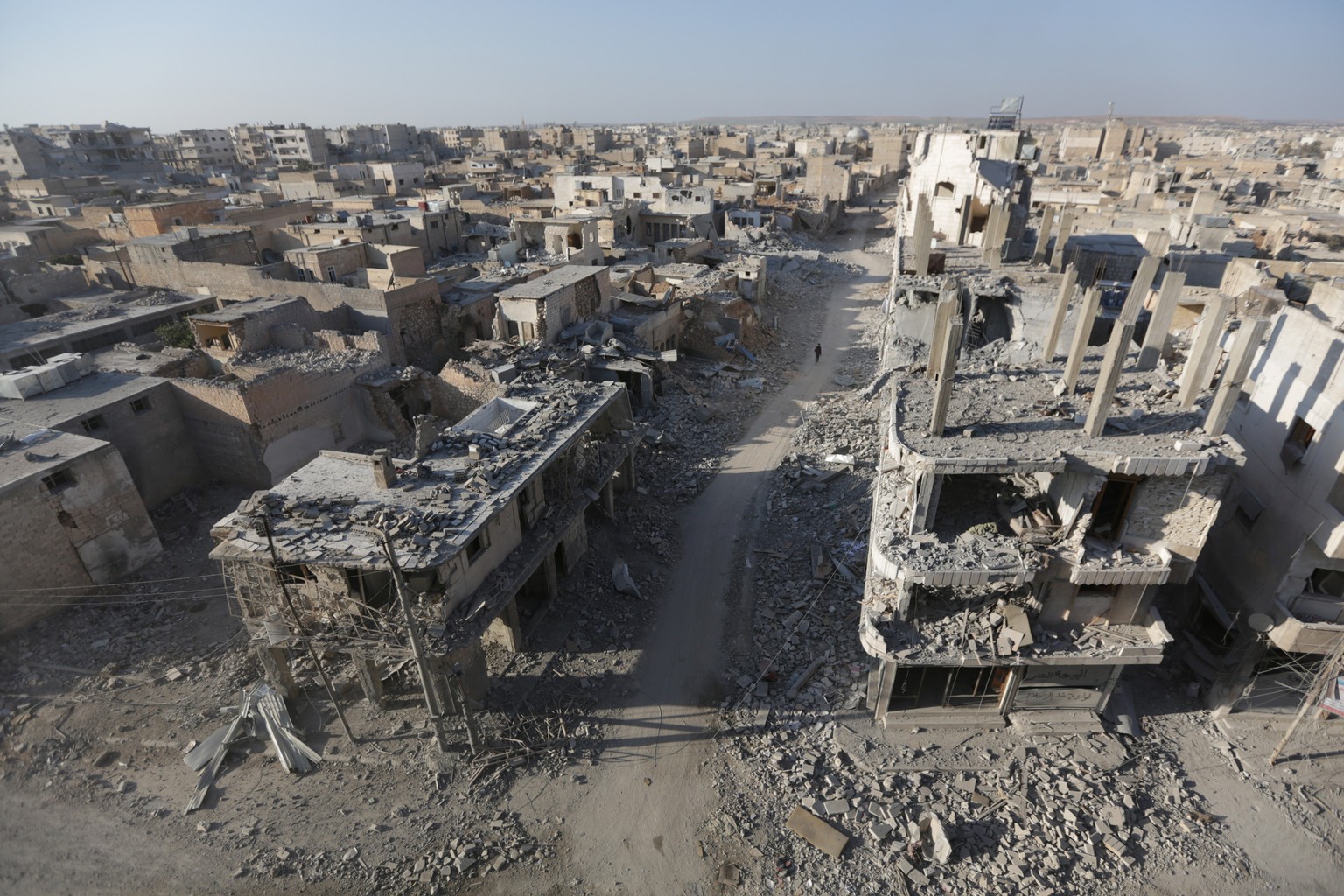 People walk along a damaged neighbourhood in the northern Syrian town of al-Bab, Syria March 6, 2017. REUTERS/Khalil Ashawi