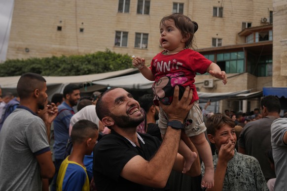 Palestinians celebrate following the announcement that Israel and Hamas have agreed to the first phase of a peace plan to pause the fighting, outside Al-Aqsa Hospital in Deir al-Balah, central Gaza St ...