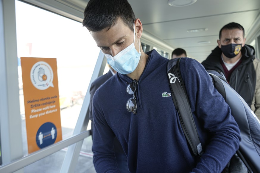 Novak Djokovic looks as his documents after landing in Belgrade, Serbia, Monday, Jan. 17, 2022. Djokovic arrived in the Serbian capital following his deportation from Australia on Sunday after losing  ...