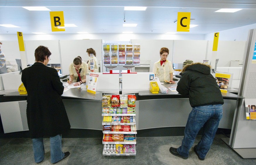 ARCHIV - ZUR HALBZEITBILANZ DES UMBAUS DES POSTNETZES STELLEN WIR IHNEN FOLGENDES BILDMATERIAL ZUR VERFUEGUNG - Angestellte der Post, bedienen am 2. Maerz 2007 an den Postschaltern B und C in Sursee K ...