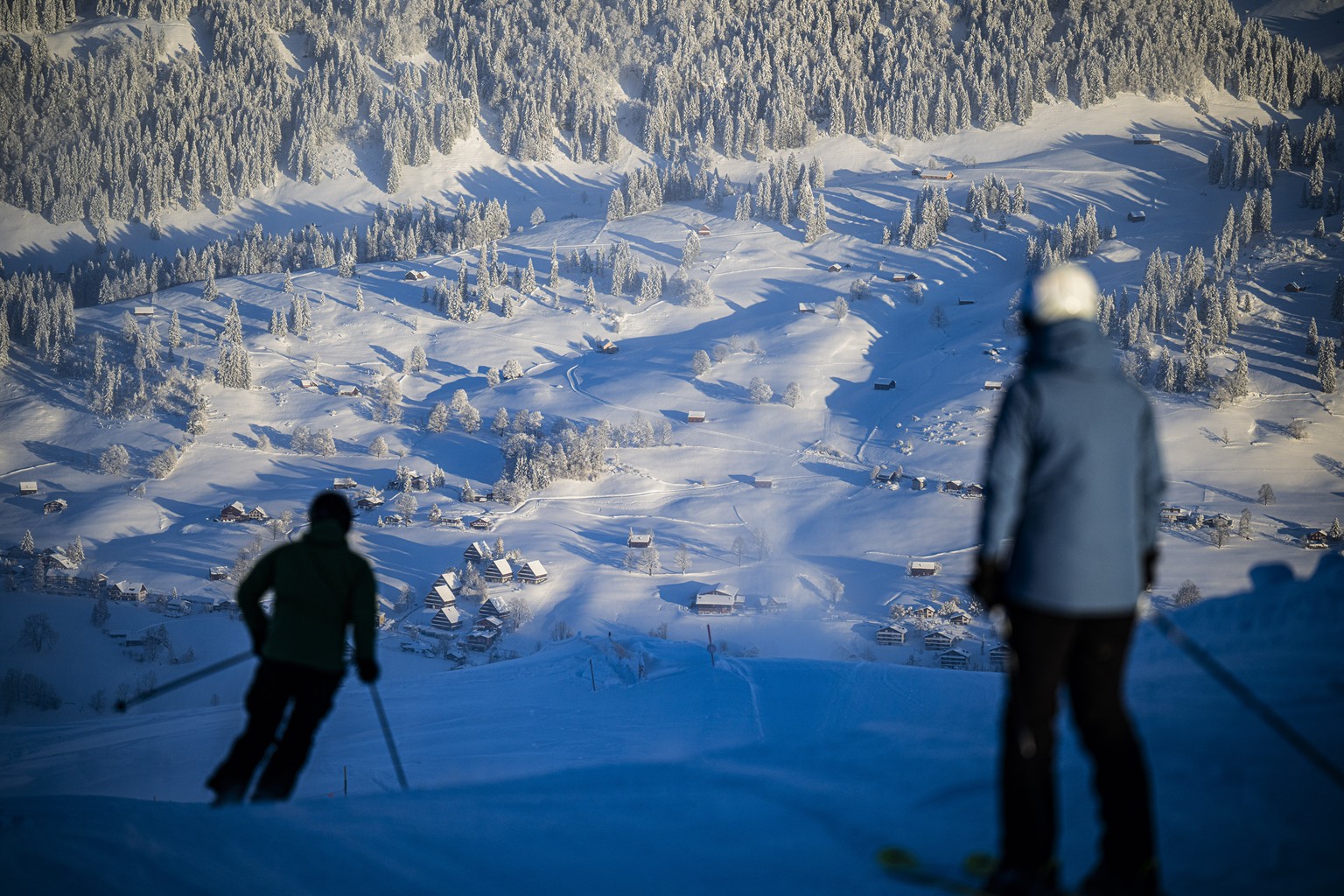 epa11008681 People ski after heavy snowfall on the start of the pre-season, in Wildhaus, Switzerland, 03 December 2023. EPA/GIAN EHRENZELLER