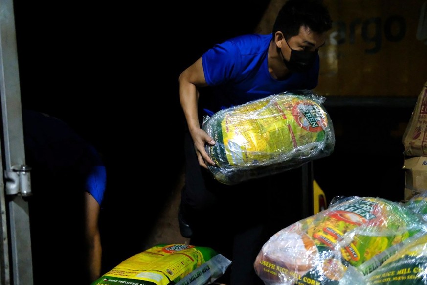 epa09649380 A handout photo made available by the Office of the Vice President (OVP) shows a worker unloading sacks of relief goods in Cebu city, Philippines, 19 December 2021. According to the Nation ...