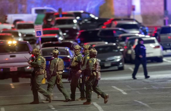 Law enforcement agents walk in the parking lot of a shopping mall, Wednesday, Feb. 15, 2023, in El Paso, Texas. Police say one person was killed and three other people were wounded in a shooting at Ci ...