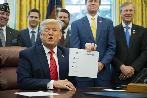 FILE - President Donald Trump shows a paper with names of four U.S. companies worth over a trillion dollar to emphasize how good the economy is doing during the Supporting Veterans in STEM Careers Act ...