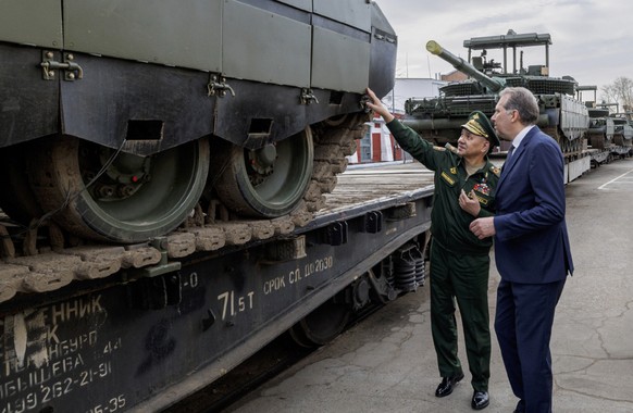 epa11297665 A handout photo made available by the Russian Defence Ministry Press-Service shows Russian Defense Minister Sergei Shoigu (C) inspecting the implementation of the state defense order at th ...