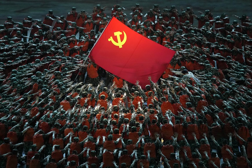 Performers dressed as rescue workers gather around the Communist Party flag during a gala show ahead of the 100th anniversary of the founding of the Chinese Communist Party in Beijing on Monday, June  ...