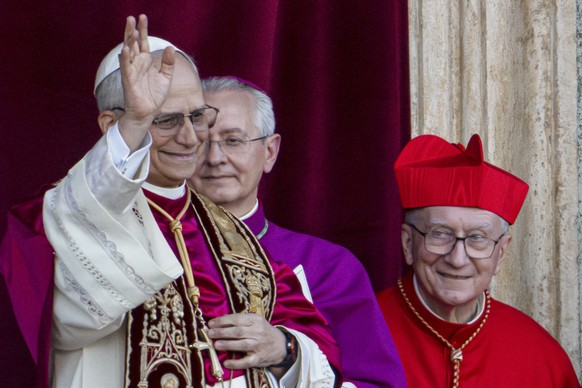 Newly elected Pope Leo XIV, left, formerly Cardinal Robert Francis Prevost, appears with, from left, Master of Ceremonies Archbishop Diego Giovanni Ravelli, and former Vatican Secretary of State Cardi ...