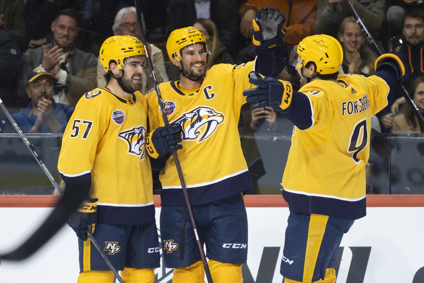 Nashville's Roman Josi, center, celebrates with his teammates Dante Fabbro, left, and Filip Forsberg, right, after scoring the 1-1 during the NHL Global Series Challenge ice hockey match between SC Be ...