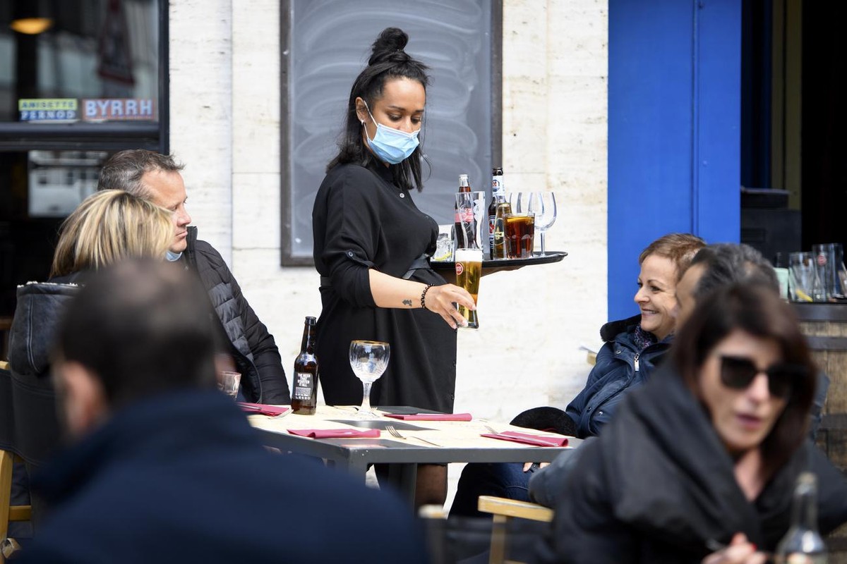 A waitress wearing a face protection mask serves lunch on the terrace of the "L'Etoile Blanche" the opening day of the terrace, restaurants can only open their terraces but indoor rooms ...