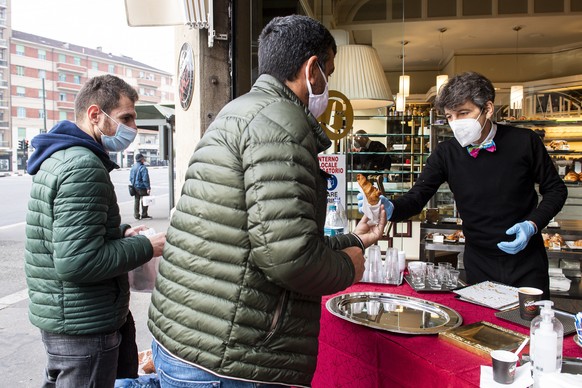 A bar serves take-away customers in Turin, Italy, Friday, Nov. 6, 2020. Piedmont is among the four Italian regions classified as red zones, where a strict lockdown was imposed starting Friday - to be  ...