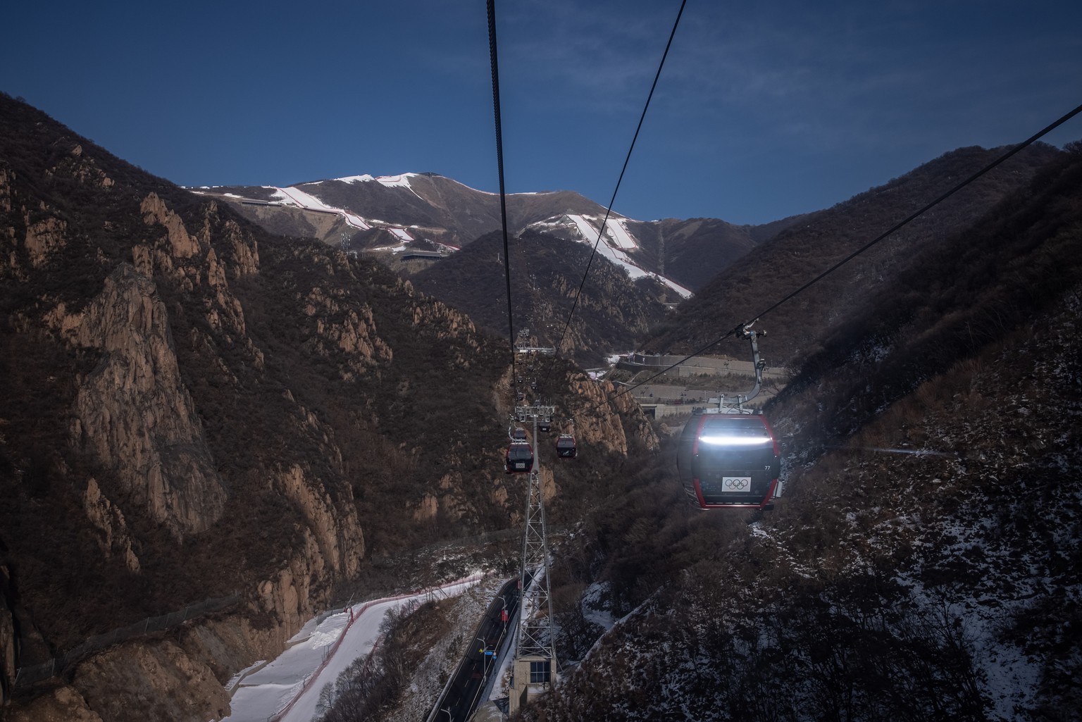 epa09718004 Gondolas lifts at Yanqing National Alpine Skiing Center, the Olympic venue for alpine skiing, in Beijing, China, 30 January 2022. The Beijing 2022 Winter Olympics is scheduled to start on  ...