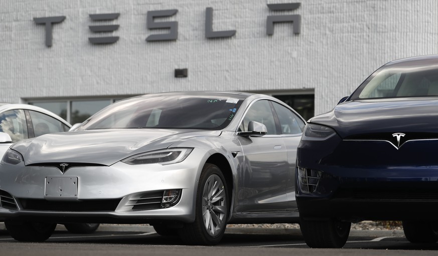 In this July 8, 2018, photo, 2018 Model 3 sedan sits next to a Model X on display outside a Tesla showroom in Littleton, Colo. Board members at Tesla are evaluating CEO and Chairman Elon Musk’s $72 bi ...