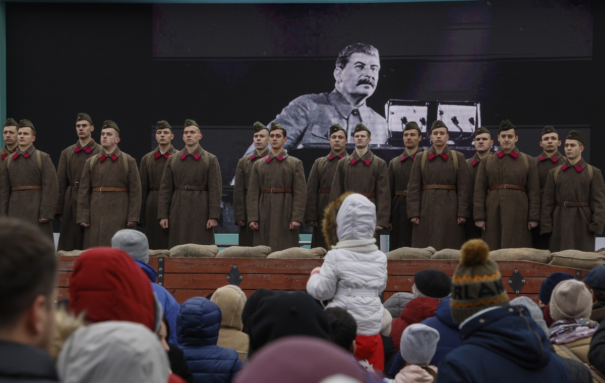 epa10287914 A Russian choir with its members dressed as Soviet-era soldiers perform in front of a picture of Joseph Vissarionovich Stalin (background) during an exhibition dedicated to the 'Russi ...