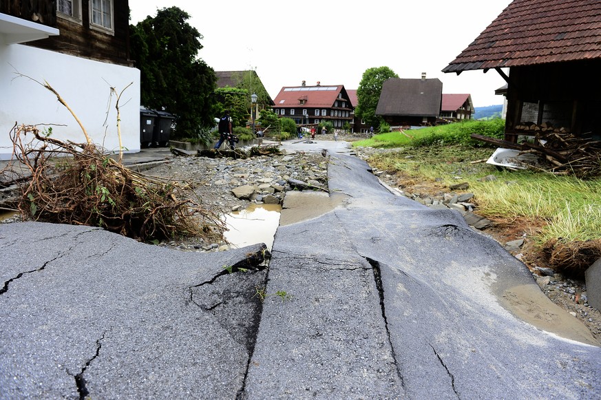 Unwetterschaeden in Dierikon LU, am Montag, 8. Juni 2015. In Dierikon ueberflutete der Dorfbach nach heftigen Regenfaellen  gestern Abend Garagen und riss ganze Strassenabschnitte weg. Eine 32-jaehrige Frau und ihre fuenfjaehrige Tochter sind nach dem heftigen Unwetter vom Sonntagabend im Untergeschoss ihres Hauses ertrunken. Heftige Gewitter haben am Sonntagabend und in der Nacht fuer hunderte Feuerwehreinsaetze gesorgt. Besonders stark betroffen waren Bern, Zuerich und die Zentralschweiz. (KEYSTONE/Urs Flueeler)