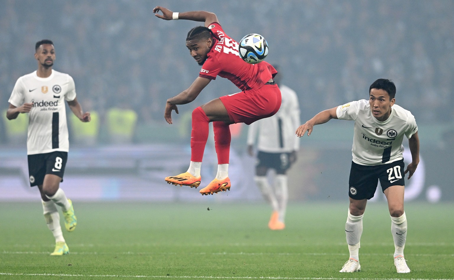 epa10671359 Djibril Sow of Eintracht Frankfurt (L) and Makoto Hasebe of Eintracht Frankfurt (R) in action with Christopher Nkunku of RB Leipzig (C) during the German DFB Cup final soccer match between ...