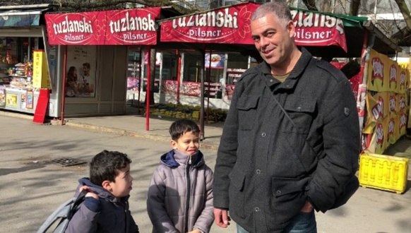 Ein Mann steht mit seinen zwei Söhnen an einer Busstation in Tuzla, Bosnien: Die Familie versucht, nach Frankreich zu gelangen.