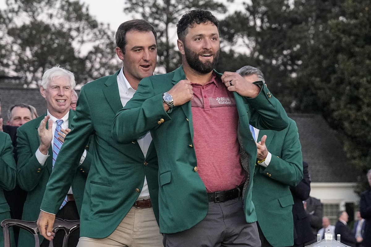 Scottie Scheffler puts the green jacket on Jon Rahm, of Spain, after Rahm won the Masters golf tournament at Augusta National Golf Club on Sunday, April 9, 2023, in Augusta, Ga. (AP Photo/David J. Phi ...