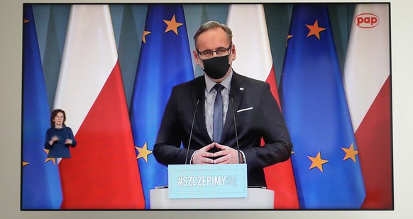 epa09095669 A television screen shows Polish Health Minister Adam Niedzielski during a press conference on the coronavirus pandemic situation in Warsaw, Poland, 25 March 2021. Poland reported 34,151 n ...