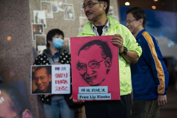 epa05082198 Activists with the Hong Kong Alliance in Support of Patriotic Democratic Movements of China celebrate the 60th birthday of imprisoned human rights activist and 2010 Nobel Peace Prize laure ...