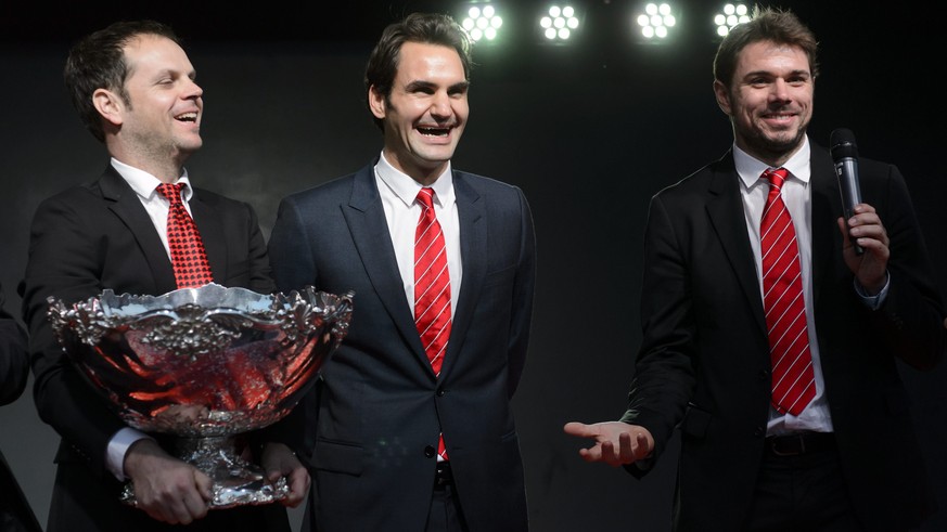 epa04502330 Swiss Davis Cup Team captain Severin Luethi, left, and tennis players Roger Federer, center, and Stanislas &quot;Stan&quot; Wawrinka, right, pose with the Cavis Cup Trophy, one day after w ...