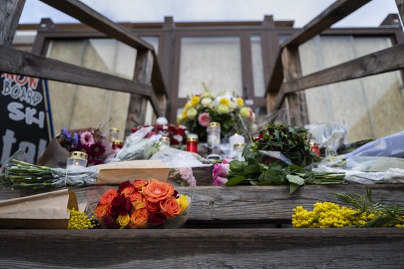Candles and flowers mark the entrance of the "Le Constellation" bar after the fire at the "Le Constellation" bar and lounge, in Crans-Montana, Switzerland, Friday, January 30, 2026 ...