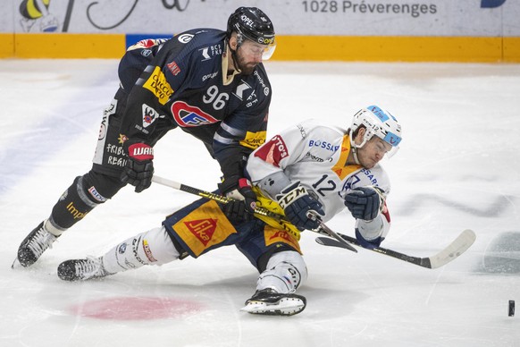 Fribourgs, Adrien Lauper, links, im Duell mit Zugs, Yannik Zehnder, rechts, waehrend dem Meisterschaftsspiel der National League, zwischen dem HC Fribourg-Gotteron und dem EV Zug, am Dienstag 25. Febr ...