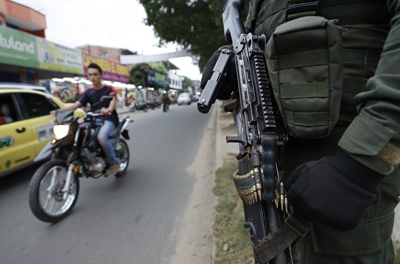 epa09794102 A member of the police stands guard in Puerto Nariño, Colombia, 19 February 2022 (issued 01 March 2022). A car bomb exploded on 19 January a few meters from a building in the city of Sarav ...