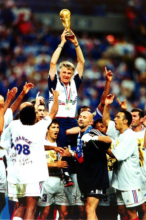 Die Spieler Lizarazu und Barthez lassen ihren Nationaltrainer Aim� Jacquet mit dem Weltpokal hochleben
