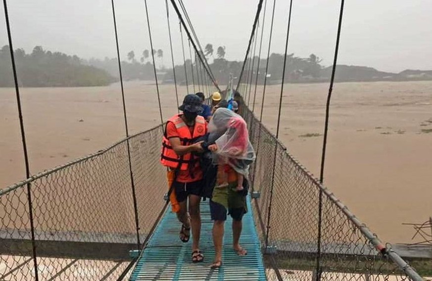 epa09644481 A handout picture made available by the Philippine Coast Guard (PCG) shows PCG personnel evacuating flood-affected residents in the typhoon-hit twon of Tubay, Agusan del Norte, southern Ph ...