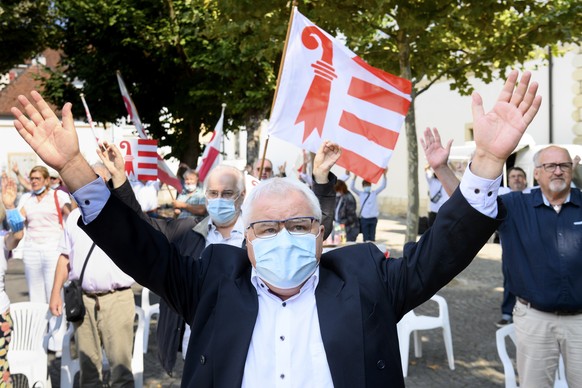 Le maire de la ville de Moutier Marcel Winistoerfer chante la rauracienne en portant un masque de protection et sans se tenir la main lors de la 73eme Fete du peuple jurassien dont le programme a ete  ...