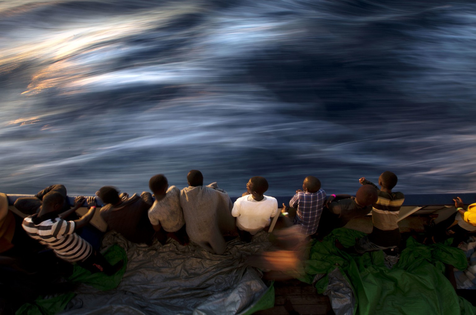 Migrants and refugees stand on the deck of the vessel Golfo Azzurro after being rescued by Spanish NGO Proactiva Open Arms workers on the Mediterranean Sea, Friday, June 16, 2017. A Spanish aid organi ...