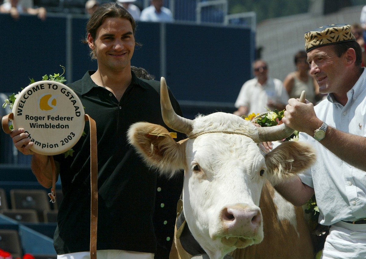 Wimbledon men's singles tennis champion Roger Federer, left, poses next to Juliette, the cow he was presented by the direction of the Allianz Suisse Tennis Open for his victory in Wimbledon, at t ...