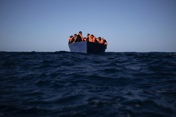 Migrants from Eritrea, Egypt, Syria and Sudan, wait to be assisted by aid workers of the Spanish NGO Open Arms, after fleeing Libya on board a precarious wooden boat in the Mediterranean sea, about 11 ...